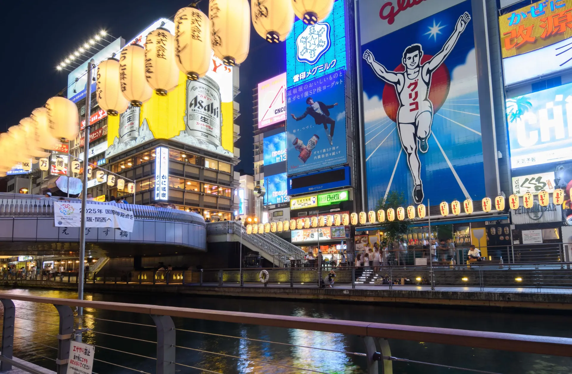 難波・道頓堀エリアの象徴的な大型ネオン看板やグリコサインなど、大阪のランドマークに掲出された大規模な屋外広告(OOH)のイメージ(Adobe Stockより引用)