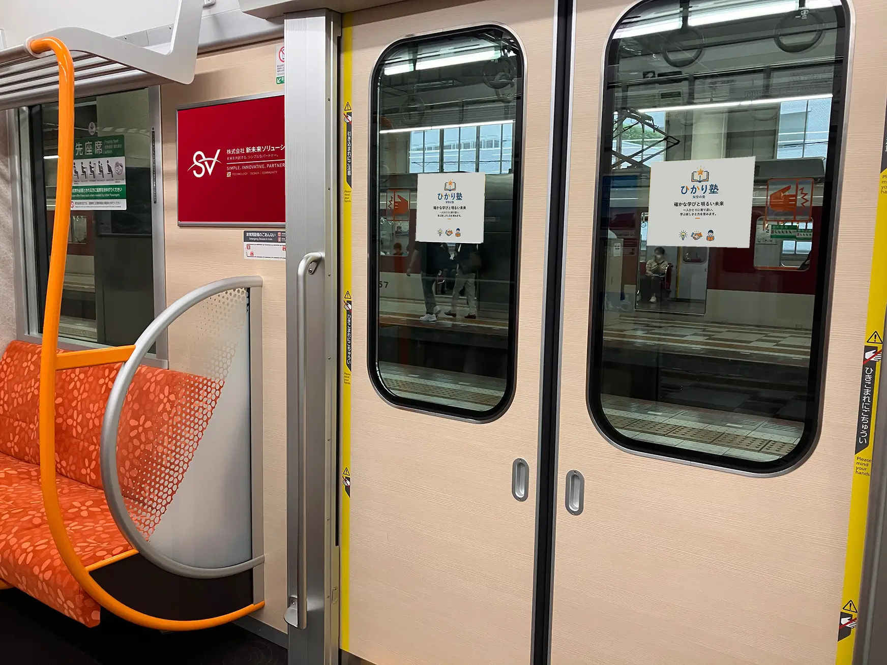 電車のドア横スペースに設置された企業の額縁入りドア横ポスター広告、ドアステッカーの掲出イメージ