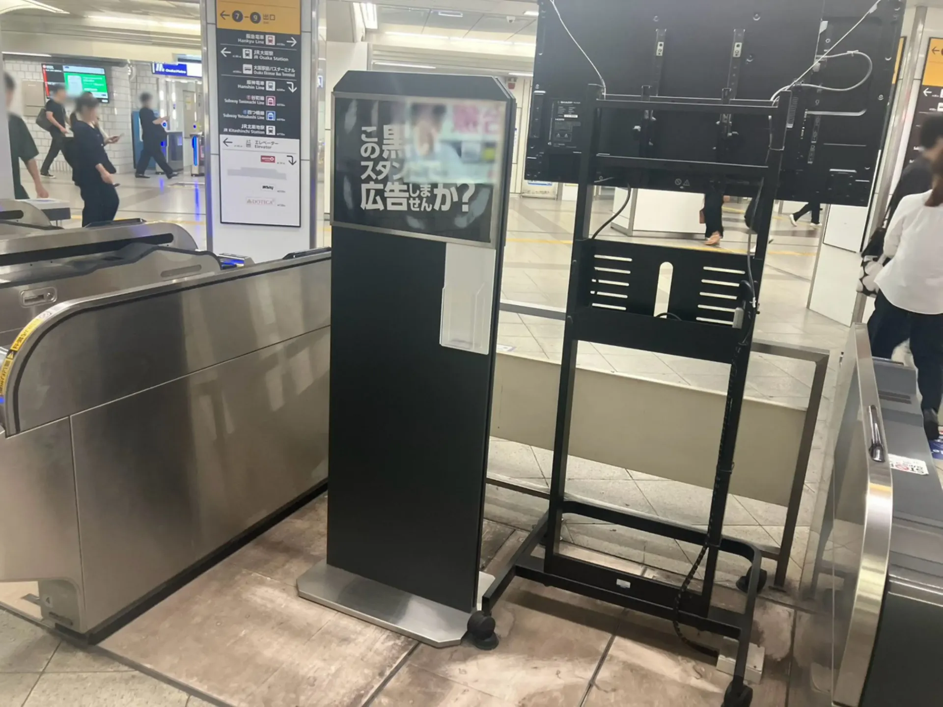 大阪メトロ御堂筋線梅田駅の中南改札横に設置された時刻表ラッピング広告かいさつ君の表面